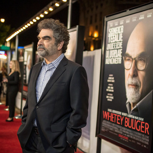 Joe Berlinger at film festival premiere. Wearing dark suit and checked shirt. Surrounded by movie posters of Whitey Bulger