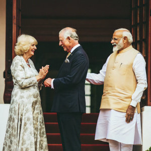 Formal photo: Prince Charles, Camilla, and Narendra Modi exchange greetings. White background with no flags visible.