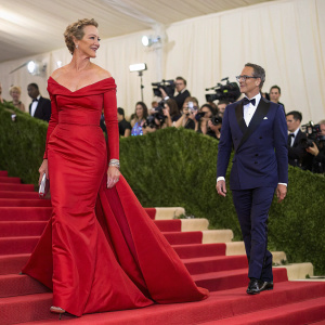 Janet McTeer in a red floor-length gown and Joe Coleman in a navy tuxedo. Walking down the aisle at the Met Gala.