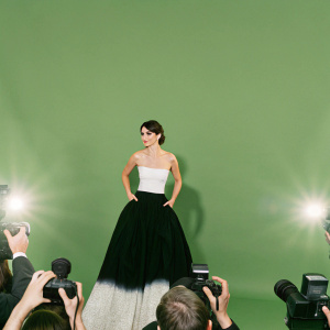 Penelope Cruz, in a black and white gown, center of attention at Cannes. Crowds of photographers flash their cameras.