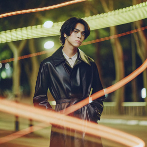 NCT Lucas, korean male idol, dressed in a sleek black leather jacket, with a serious look. Abstract neon-lit cityscape background