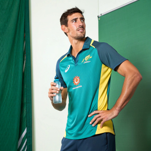 Mitchell Starc, cricket player, posing confidently. Wearing Qantas polo shirt, holding water bottle. Green backdrop