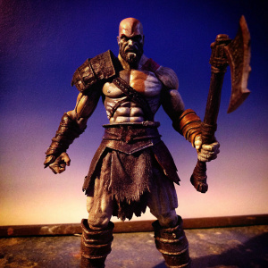 Kratos action figure. Detailed, realistic, and ready for battle pose. Dark, plain background. Photo