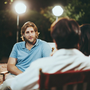 Actor Curtis Stone in a casual interview setting. Wearing a blue polo shirt. Bright lights, no background
