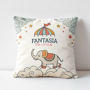 Close-up of a rectangular pillow featuring a cartoonish elephant and cloud design. The pillow displays the logo 'Fantasia - The Circus' in a playful font. White background.