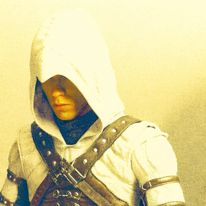 Detailed close-up of an Assassin's Creed cosplay. White hooded cloak, brown leather armor, and intricate accessories. Grey studio background