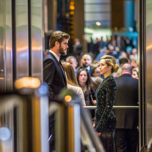 Liam Hemsworth and Miley Cyrus at a high-profile gala. Liam in a traditional black suit, Miley in a dazzling black sequined gown. Crowded indoor event, blurred faces in background
