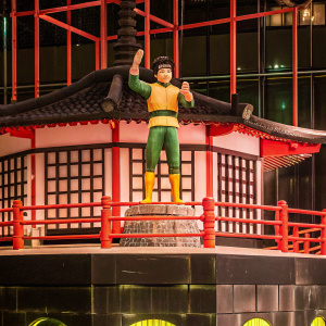 Digital art featuring Rock Lee from Drunken Master. Vibrant colors and dynamic pose. On a black backdrop, special base with intricate design.
