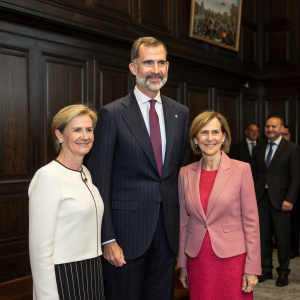 Formal gathering with King Felipe VI, Dr. Angelica Schwall-Dueren, and Liz Mohn at Bertelsmann headquarters. Dark wooden paneling backdrop, professional expressions.
