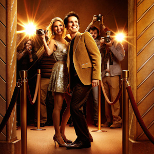 Hal Sparks and a blonde woman, both grinning widely, on the bustling Hollywood red carpet. Surrounded by flashing cameras at the Radio Disney Music Awards.