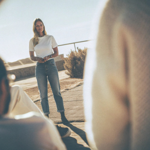 Bar Refaeli in candid photo shoot. Dressed in casual attire, standing outdoors on sunny day. White t-shirt, blue jeans