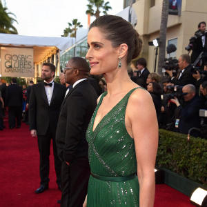 Amanda Peet, elegant in a green sequined dress, at the Golden Globe Awards. Crowded event with red carpet.