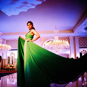 Bipasha Basu, Indian actress, in an elegant emerald green dress, poses confidently. Luxurious event venue backdrop