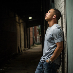 Kolten Wong, #16, in a casual t-shirt and jeans. Standing in a dimly lit alley. He appears contemplative.