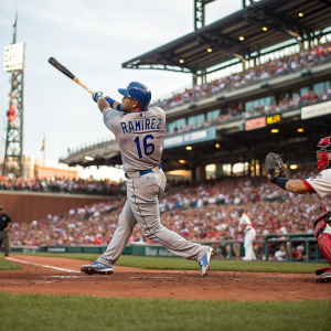 Aramis Ramirez, in gray jersey number 16, swinging at pitch in a packed stadium. The crowd's faces and the stadium's grandeur in the background.