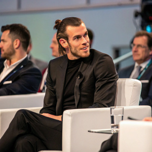 Gareth Bale during a Q&A session at a sports conference. Wearing a sleek black suit.