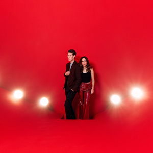 Matt Smith and Eliza Dushku at the premiere event. Matt in dark suit, Eliza in black top and leather pants. Crowded venue with flashing lights