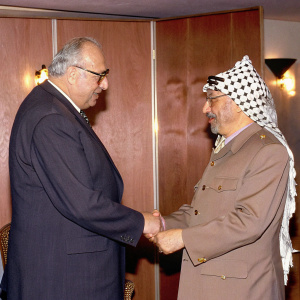 Formal meeting between Helmut Kohl and Yasser Arafat. Historical handshake. Warm lighting, wooden paneling backdrop