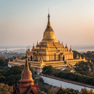 From a low angle, a stunning golden temple dominates the view. Soaring spires and intricate details define this Southeast Asian architectural marvel.