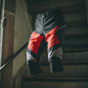 Close-up of rugged biking shorts, Alpinestars Outrider BASE WR, highlighted in black and vibrant red.