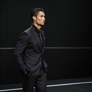 Cristiano Ronaldo at the photocall. Dark suit, no soccer attire. Minimalist black background