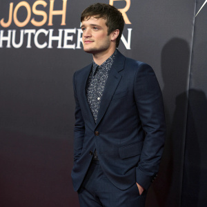 Josh Hutcherson, Caucasian male, youthful, posing for a photo shoot. Dark blue suit with a patterned shirt. Dark backdrop with promotional text. Film festival