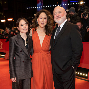 Ellen Page, Sandra Oh, and David Slade at a film festival premiere. Red carpet event, with photographers and fans in the background.