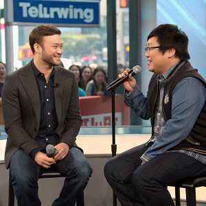Justin Timberlake and Masi Oka in a casual chat during a live talk show broadcast. Studio audience in the background.