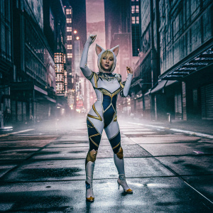 K/DA Ahri, an animated video game character. Wearing a futuristic cybernetic suit with white, blue and gold accents. Standing in a virtual cityscape, her confident pose highlighted against a neon-lit backdrop.