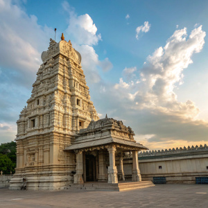 A detailed photograph showcasing the Simhadri Temple in Simhachalam, Andhra Pradesh, India. The temple, adorned with Kalinga architectural elements, stands tall with its intricate carvings and an ornate tower against a backdrop of a clear blue sky dotted with soft clouds.