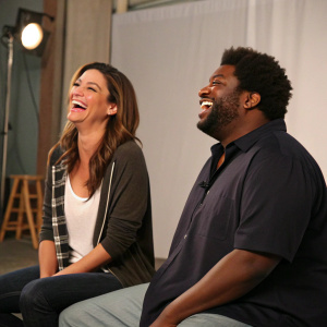 Bianca Kajlich and Ron Funches laughing together on the set of Undateable. Studio backdrop with soft lighting