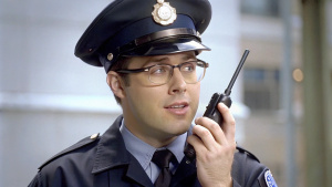 policeman in glasses talking on a walkie-talkie