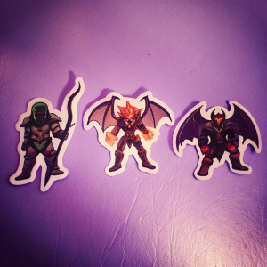 Fantasy-themed Dota 2 stickers. Green bearded archer, writhing fire creature, dark-winged warrior. White background, close-up shots