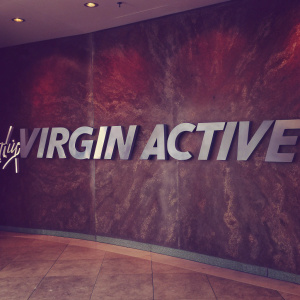 A sleek, modern logo design for 'Virgin Active' featuring bold, white letters on a deep red backdrop, conveying a dynamic and energetic vibe.