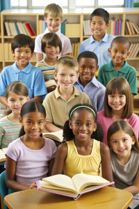 Multicultural group of kids sit at tables with books and study at primary school. Education, knowledge, development or studying