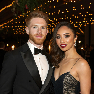 Neil Jones and Katya Jones attending an awards gala. Elegant attire and sophisticated makeup. Soft ambient lighting
