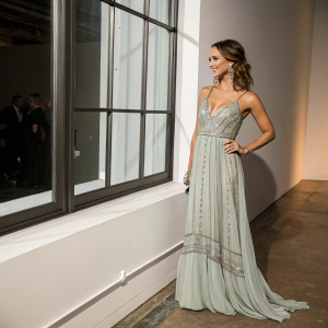 Jessica Alba at an indoor gala, elegant evening dress, standing beside a large window. Minimalist backdrop