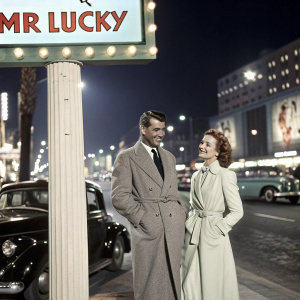 Promotional billboard for 'Mr Lucky'. Features Cary Grant and Lariaine Day in a retro Hollywood style.