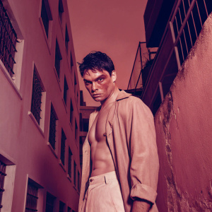 Tyler Durden lookalike with a bruised face and intense stare. Dark alleyway backdrop, gritty and urban setting.