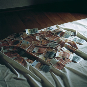 Variety of crumpled euro banknotes, featuring denominations of 20, 50, scattered on a pristine white surface.