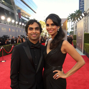 Kunal Nayyar and Neha Kapur at the 64th Primetime Emmy Awards, posing on the vibrant red carpet.