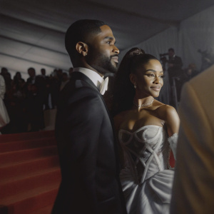 Big Sean and Ariana Grande posing at the MET Gala, wearing formal attire. Big Sean in a sleek black tuxedo, Ariana in a stunning white gown with intricate detailing. The backdrop is a vibrant mix of red carpet and celebrity guests.