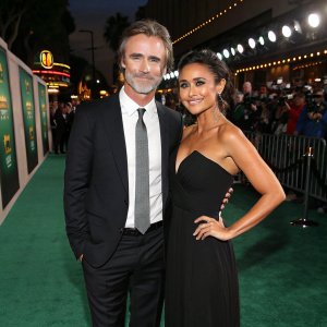 Sam Trammell and Emmanuelle Chriqui at a glamorous green carpet event. Wearing formal attire, posing for cameras.