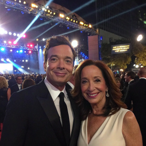Jimmy Fallon and Lilly Tartikoff at the awards show. Bright stage lights, bustling crowd in background