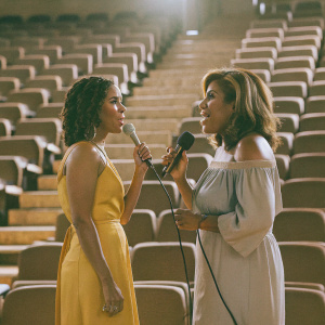 Jada Pinkett Smith and Hoda Kotb at SiriusXM. Vibrant yellow dress, off-the-shoulder blouse. Studio audience in the background.