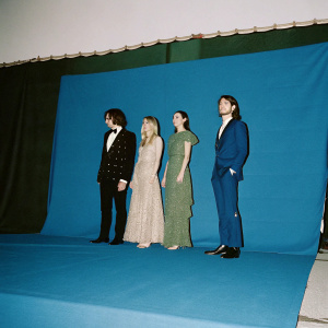 Riccardo Nicoletti, Francesca Ferragni, Valentina Ferragni, and Luca Vezil attending a glamorous gala event. They are all dressed in elegant evening wear, standing on a stage with vibrant, colorful banners behind them.
