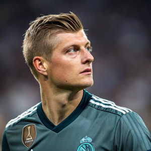 Soccer star Toni Kroos, with a modern haircut, serious look. Shot at UEFA Champions League, blurred stadium background