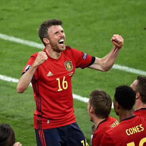 Michael Carrick, celebrating with teammates on the football pitch, wearing his distinctive number 16 jersey.