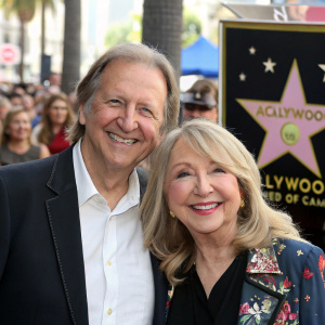 John O'Neil and Teri Garr, both smiling, at the Hollywood Walk of Fame unveiling event. Crowds in background