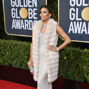 Eva Longoria at the Golden Globe Awards, wearing a luxurious fur vest and shimmering accessories.